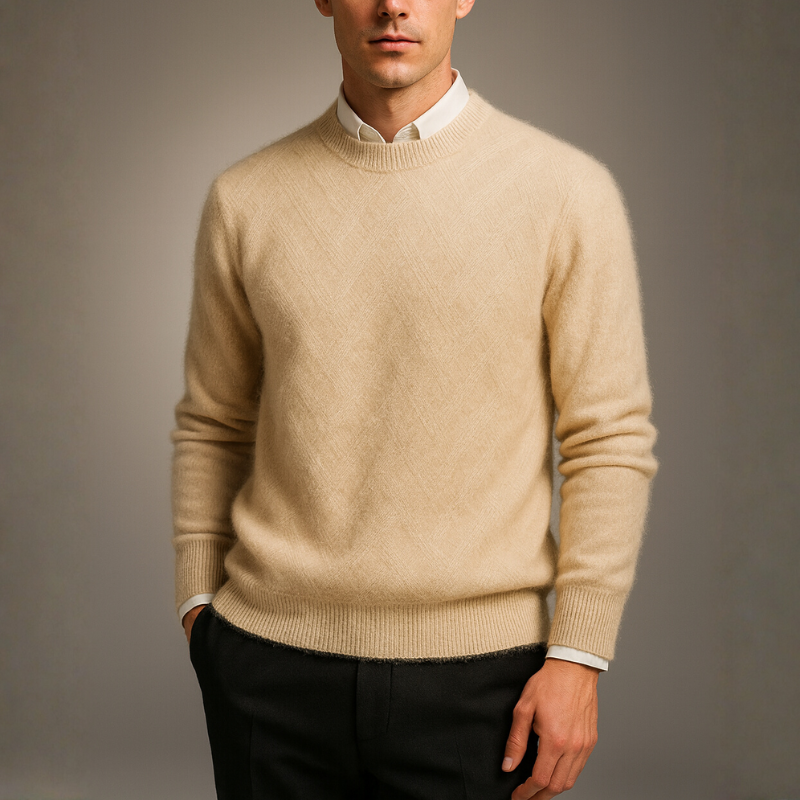 Man wearing a blue patterned sweater against a gray background