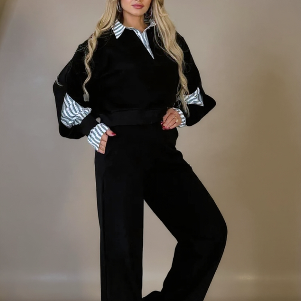 Woman wearing a black outfit with white striped sleeves against a neutral background