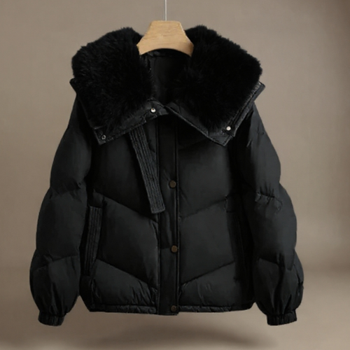 Black puffer jacket with fur collar on a wooden hanger against a brown background