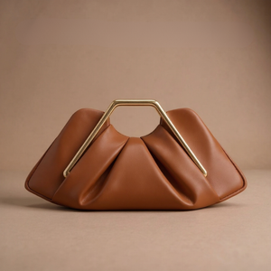 Brown handbag with a gold handle on a beige background