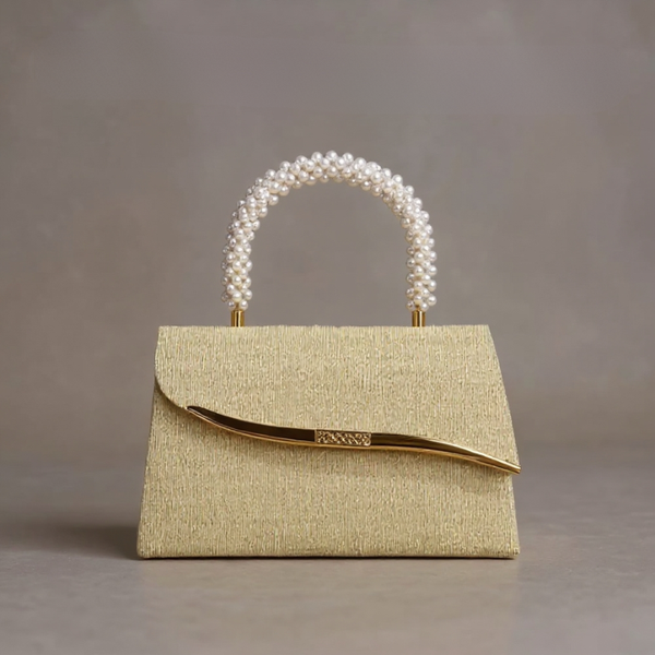 Gold handbag with pearl handle on a gray background