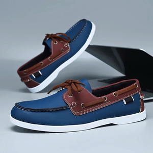 Blue and brown loafers on a reflective surface with a blurred background