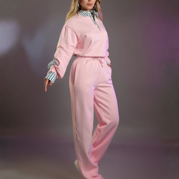 Person wearing a pink tracksuit on a dark background