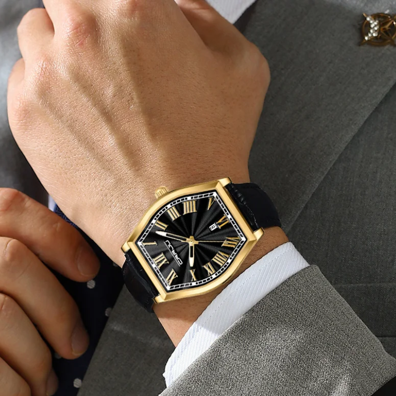 Gold and black watch on a person's wrist with a suit background