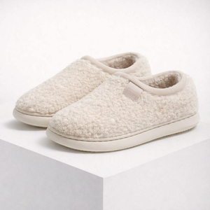 Pair of beige slippers on a white background