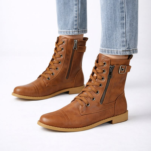 Brown leather boots with zippers worn with light blue jeans on a white background