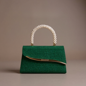 Green handbag with pearl handle on a beige background
