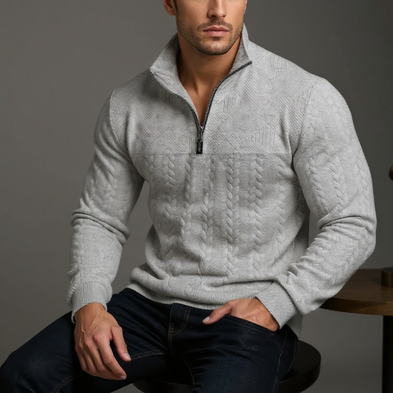 Beige cable knit sweater worn by a person on a gray background