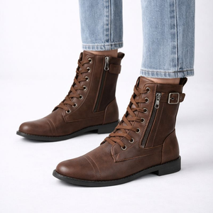 Brown leather boots with zippers worn with light blue jeans on a white background