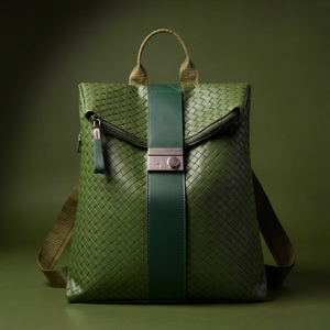 Green woven backpack with leather accents on a green background
