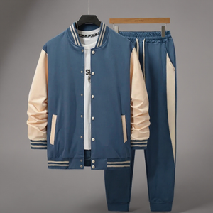 Blue and beige varsity jacket and pants set on a gray background