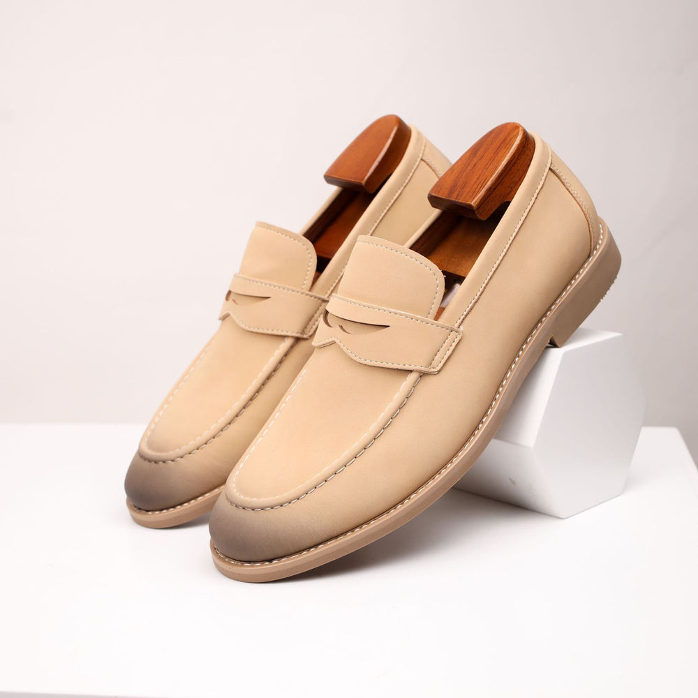 Pair of beige loafers with wooden accents on a white background