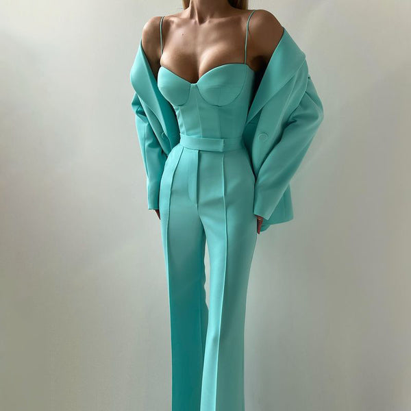 Teal jumpsuit worn by a model against a plain background