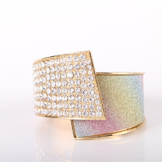 Two cuff bracelets, one with crystal embellishments and the other with a glittery finish, on a white background.