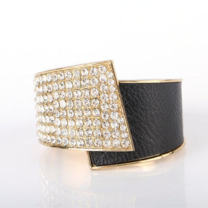 Black leather cuff with gold and crystal embellishments on a white background
