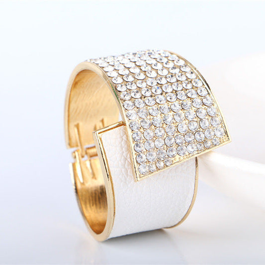 Black leather dress shoes on a wooden tray with a bow tie and watch.