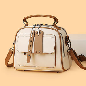White handbag with brown accents on a beige background
