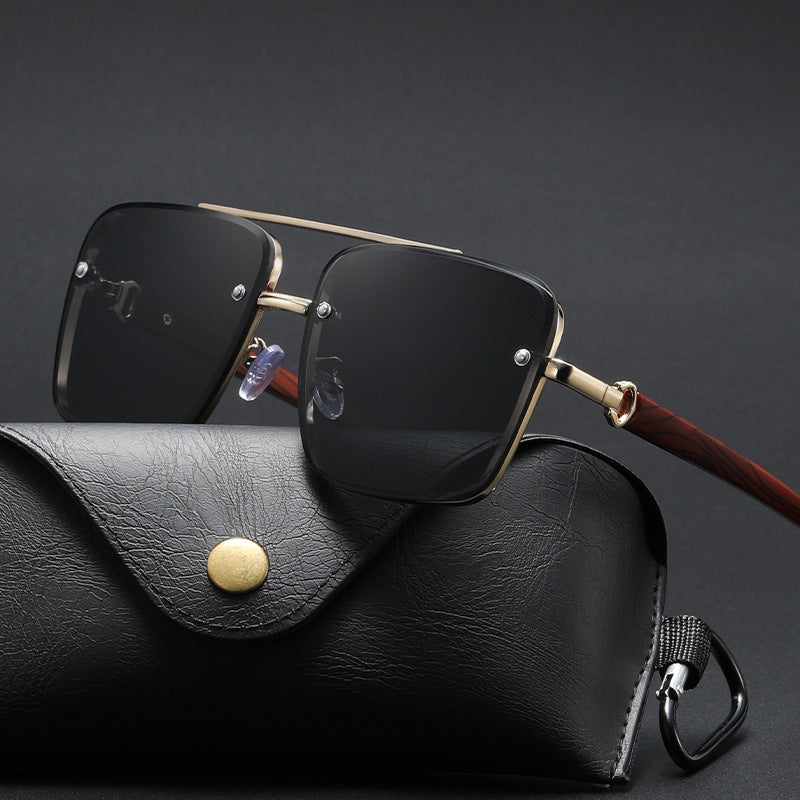 Sunglasses with gold frame and black lenses on a white surface