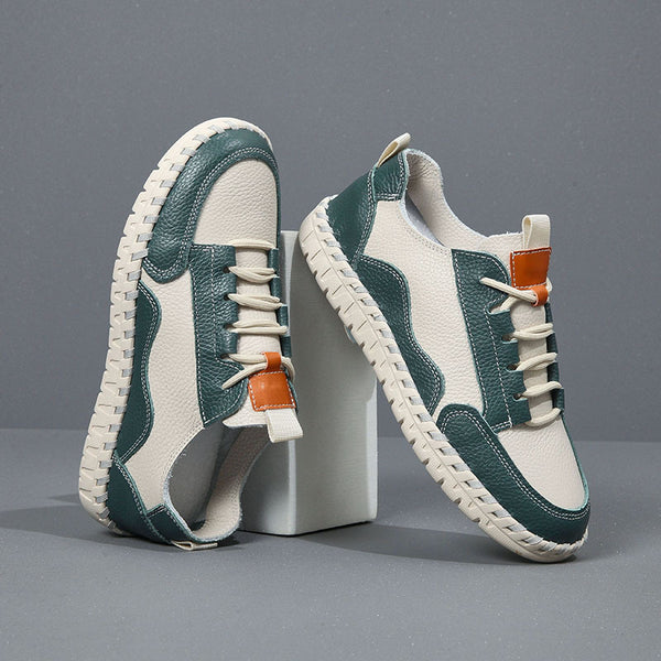 Pair of green and white sneakers with brown accents on a gray background