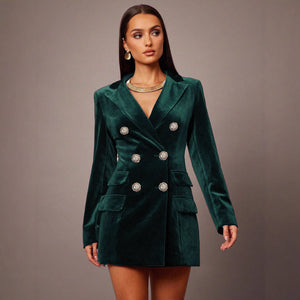 Woman wearing a green velvet blazer dress against a gray background