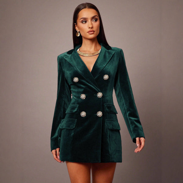 Woman wearing a green velvet blazer dress against a gray background