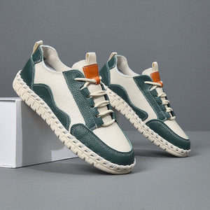 Green and white sneakers with orange accents on a gray background
