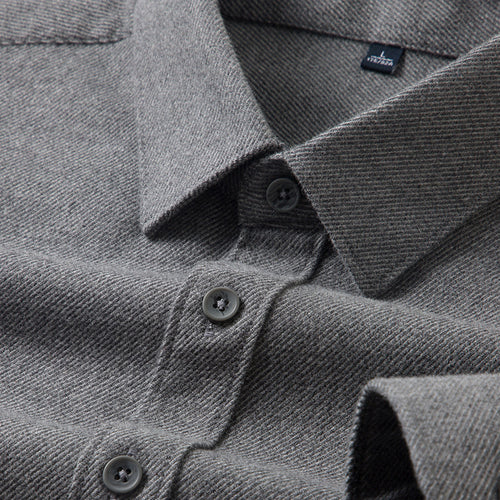 Close-up of a gray shirt with button details and a brand label.