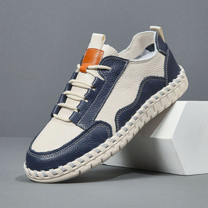 Blue and white sneaker with orange accent on a gray background