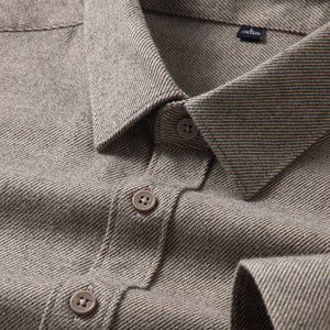 Close-up of a brown textured shirt with buttons and a visible brand label.