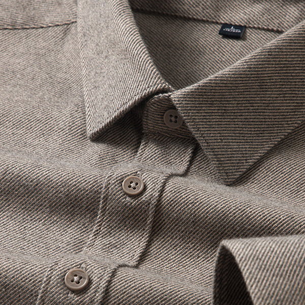 Close-up of a brown textured shirt with buttons and a visible brand label.
