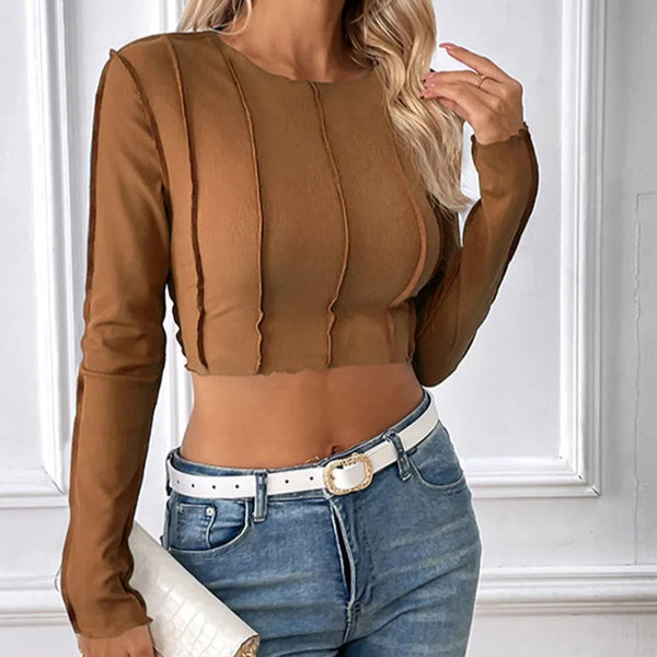 Woman wearing a brown long-sleeve top and blue jeans with a white background