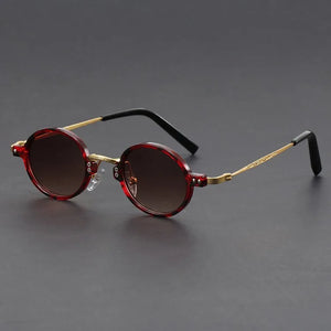Round sunglasses with red frames and dark lenses on a gray background