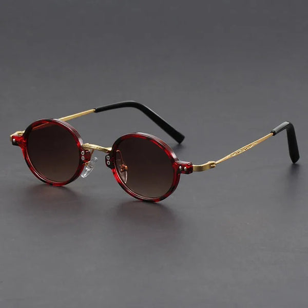 Round sunglasses with red frames and dark lenses on a gray background