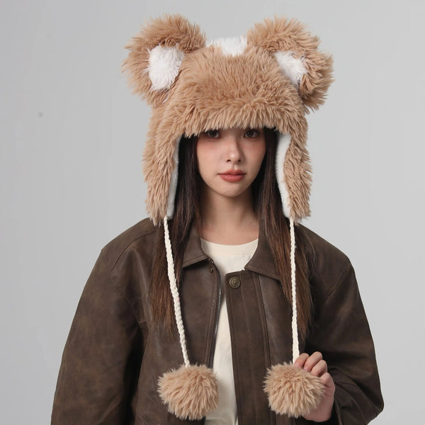 Person wearing a brown furry hat with bear ears on a gray background