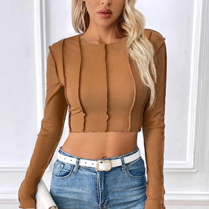 Woman wearing a brown long-sleeve top and blue jeans with a white background