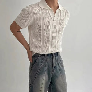 Person wearing a white knit top and blue jeans against a plain background