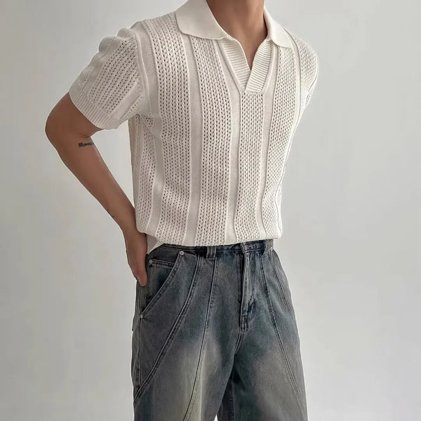 Person wearing a white knit top and blue jeans against a plain background