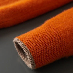 Close-up of orange fabric with a brown border on a dark surface