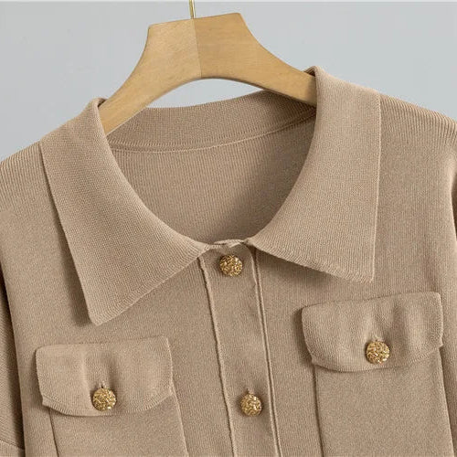 Beige jacket with gold buttons on a hanger against a gray background