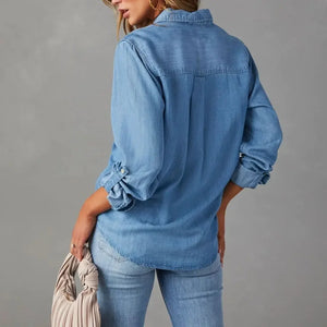 Person wearing a blue denim shirt and jeans against a gray background