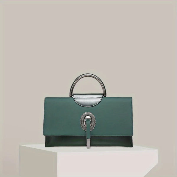 Green handbag with silver accents on a white pedestal against a light beige background