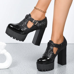 Black glittery platform shoes with chunky heels on a light gray background