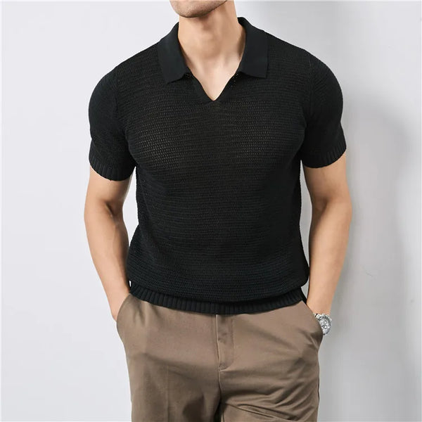 Man wearing a black textured short-sleeve shirt and brown pants on a light gray background