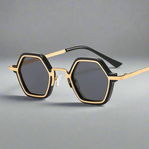 Sunglasses with gold frame and black hexagonal lenses on a white background