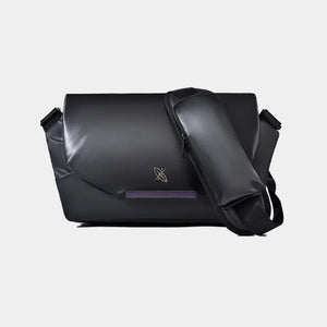 Black messenger bag with a brand logo on a light gray background