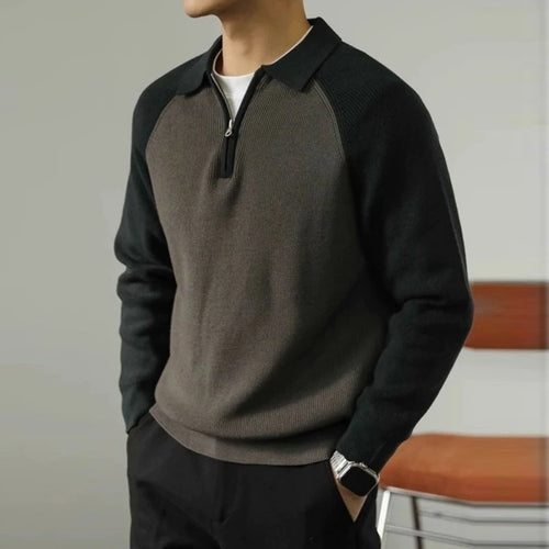 Person wearing a black and gray sweater with a blurred background