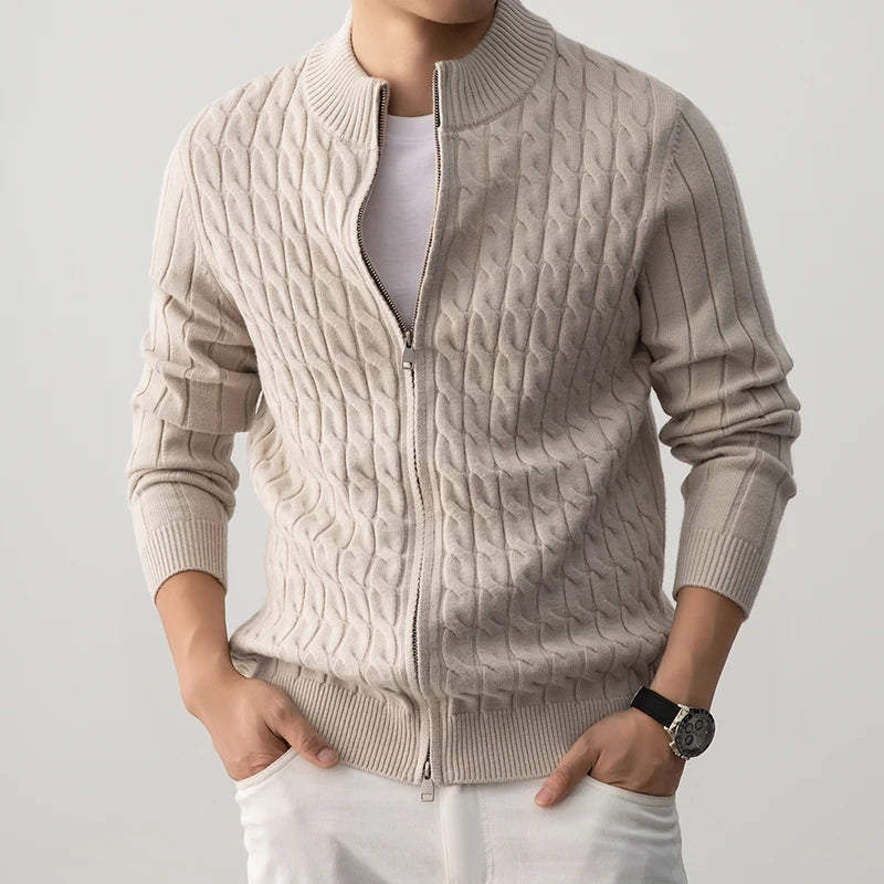 Beige cable knit sweater worn by a person on a light gray background