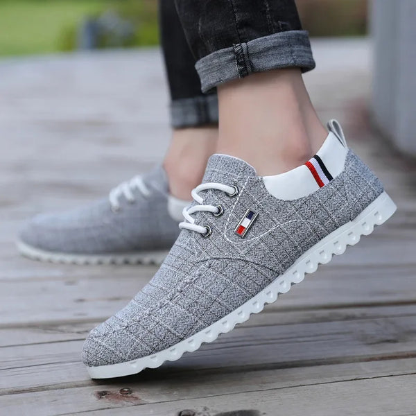 Gray sneakers with a brand logo on a wooden floor