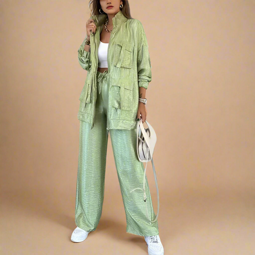 Person wearing a green outfit with a jacket and pants in an indoor setting.