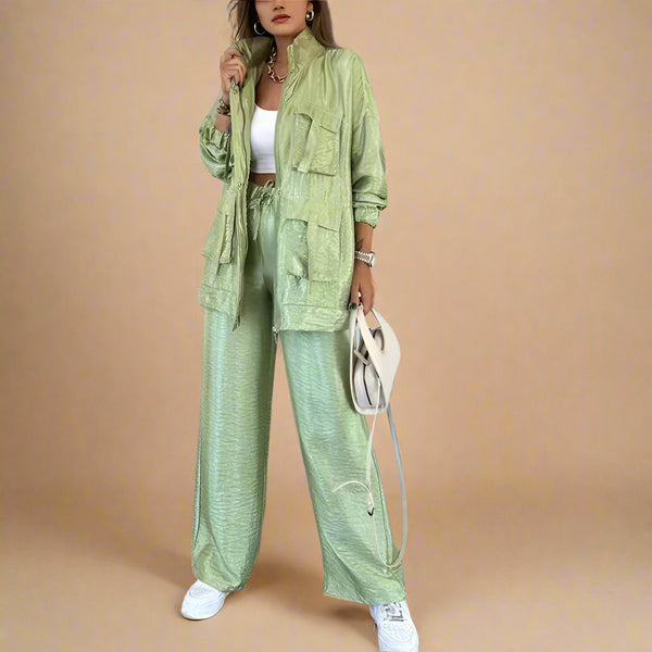 Person wearing a green outfit with a jacket and pants in an indoor setting.